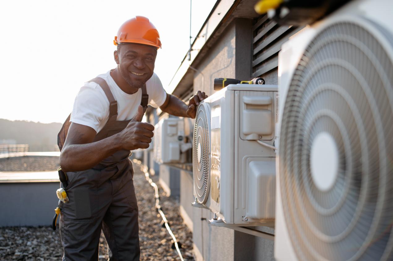 Professional HVAC technician in uniform checking air conditioning system